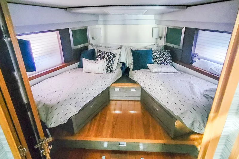 Slide: The Image of Luxurious 2020 Tiara Yachts C53 Coupe cabin with twin beds and elegant decor. - 25