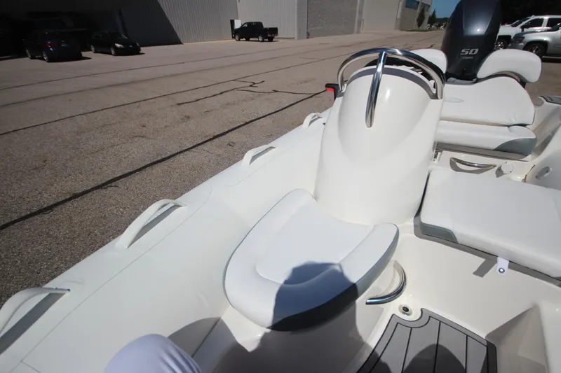 Slide: The Image of 2025 Zodiac Yachtline 400 DL NEO with 50hp engine, sleek white design, docked outdoors. - 15