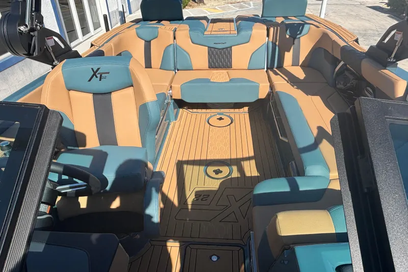 Slide: The Image of 2026 MasterCraft XT22 boat interior with tan and teal seating, showcasing luxury design. - 10