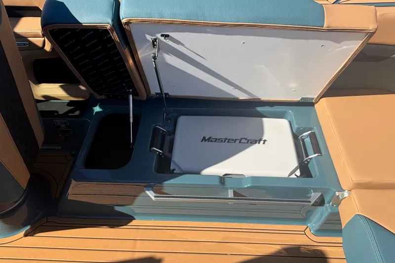 Slide: The Image of 2026 MasterCraft XT22 boat storage compartment with branded cooler and seating. - 14