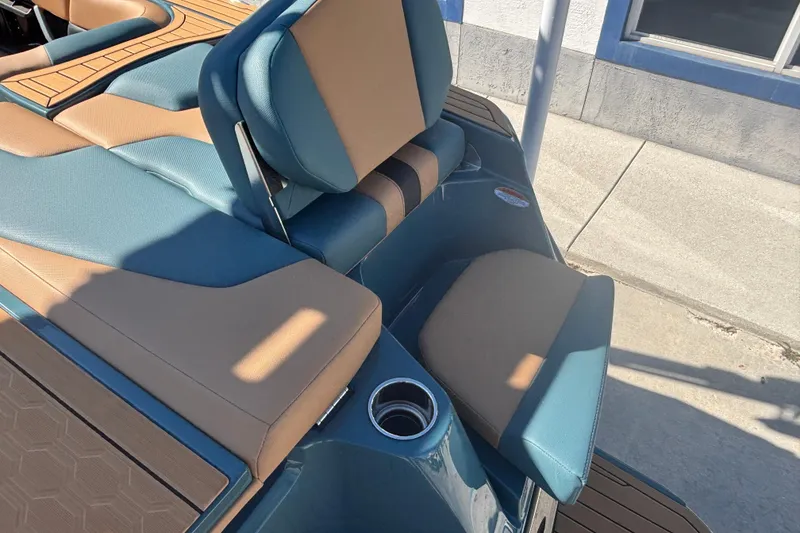 Slide: The Image of 2026 MasterCraft XT22 boat interior with tan and blue seating, cup holder detail. - 6