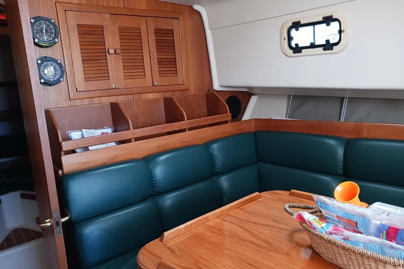 Slide: The Image of Interior of 2000 Mainship Pilot 34 Sedan with green seating and wooden cabinetry. - 10