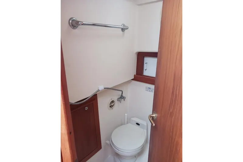 Slide: The Image of 2000 Mainship Pilot 34 Sedan bathroom with toilet and wooden cabinetry. - 16