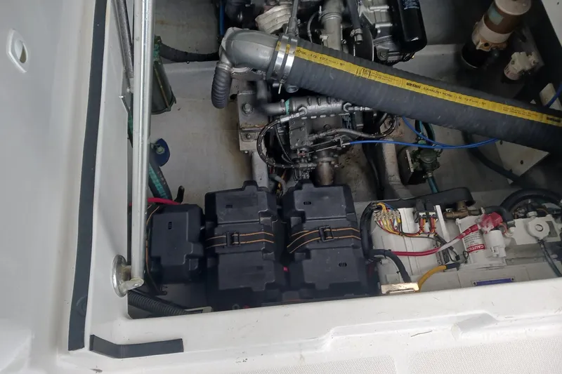 Slide: The Image of Engine compartment of a 2000 Mainship Pilot 34 Sedan, showcasing batteries and wiring. - 17
