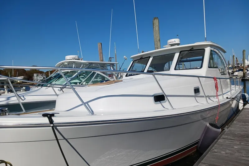 Slide: The Image of 2000 Mainship Pilot 34 Sedan docked at marina under clear blue sky. - 2
