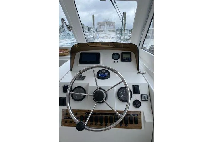 Slide: The Image of 2000 Mainship Pilot 34 Sedan helm with steering wheel and navigation instruments. - 5