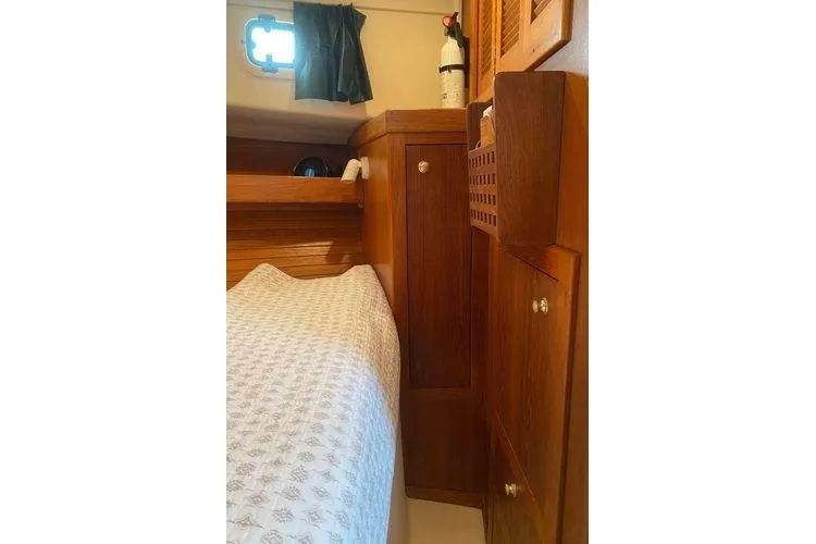 Slide: The Image of 2000 Mainship Pilot 34 Sedan cabin interior with wooden cabinetry and bed. - 9