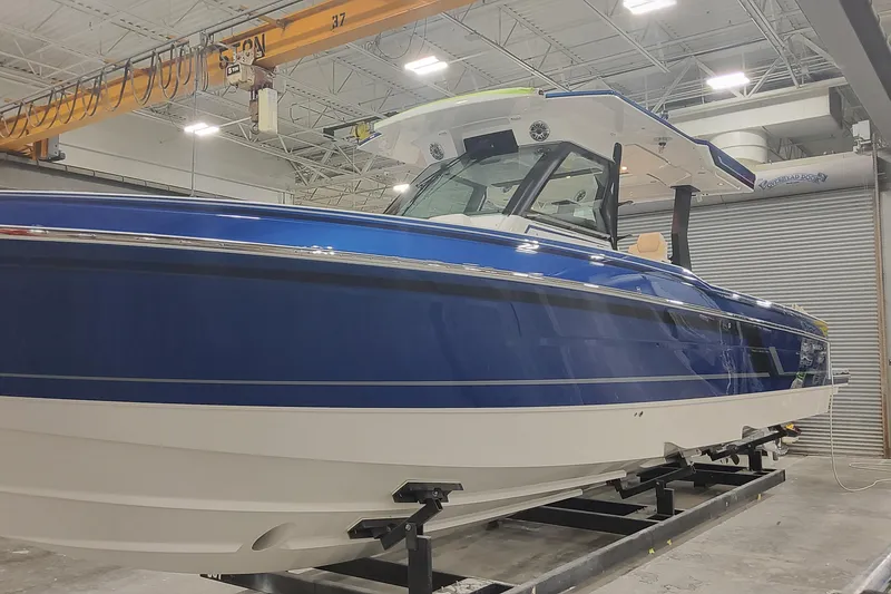 The Image of 2024 Formula 387 Center Console Fish boat in a showroom, featuring a sleek blue and white design. - 1