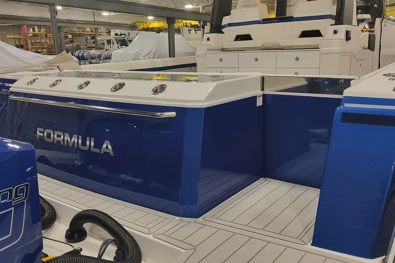 Slide: The Image of 2024 Formula 387 Center Console Fish boat in a showroom, featuring sleek blue design. - 11