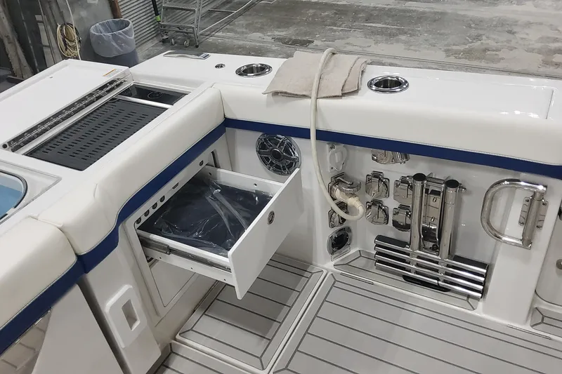 Slide: The Image of 2024 Formula 387 Center Console Fish boat interior with open storage drawer and fishing equipment. - 17