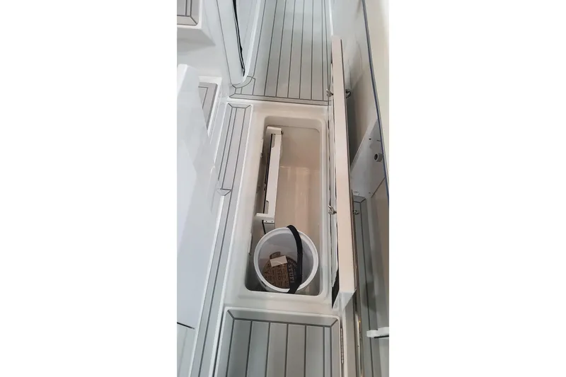 Slide: The Image of 2024 Formula 387 Center Console Fish boat storage compartment with bucket. - 36