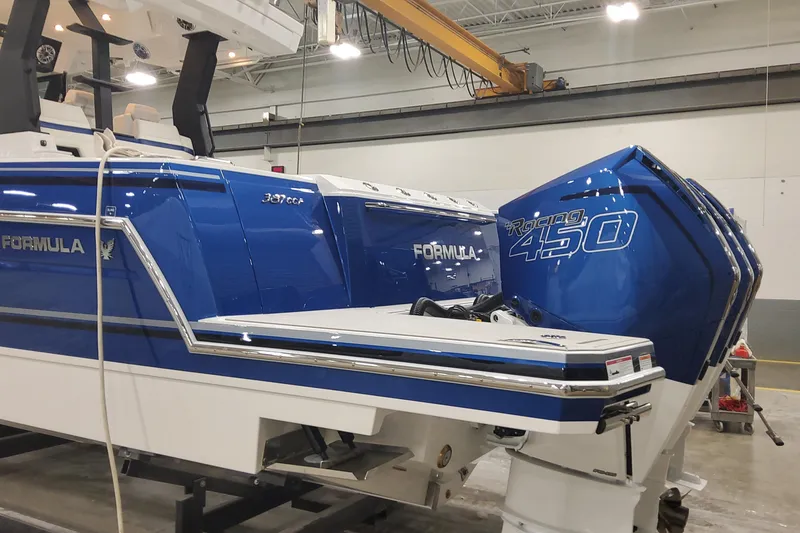 Slide: The Image of 2024 Formula 387 Center Console Fish boat with Racing 450 engines in a showroom. - 4