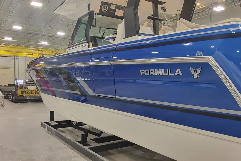 Slide: The Image of 2024 Formula 387 Center Console Fish boat in a showroom, featuring sleek blue design. - 5