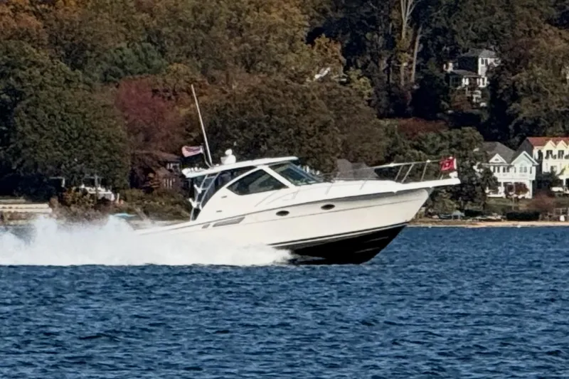 The Image of 2008 Tiara Yachts 3000 Open cruising on a scenic lake with shoreline houses. - 0