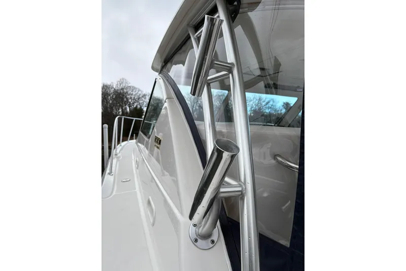 Slide: The Image of 2008 Tiara Yachts 3000 Open, close-up of fishing rod holders and cabin window. - 17