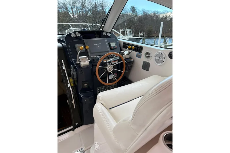 Slide: The Image of Helm of 2008 Tiara Yachts 3000 Open with steering wheel and navigation controls. - 23