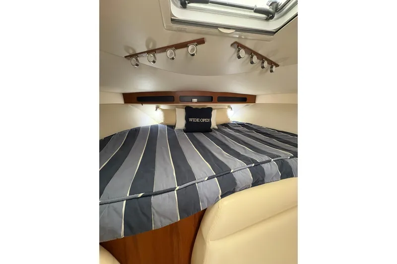 Slide: The Image of 2008 Tiara Yachts 3000 Open cabin with striped bedding and overhead lighting. - 33