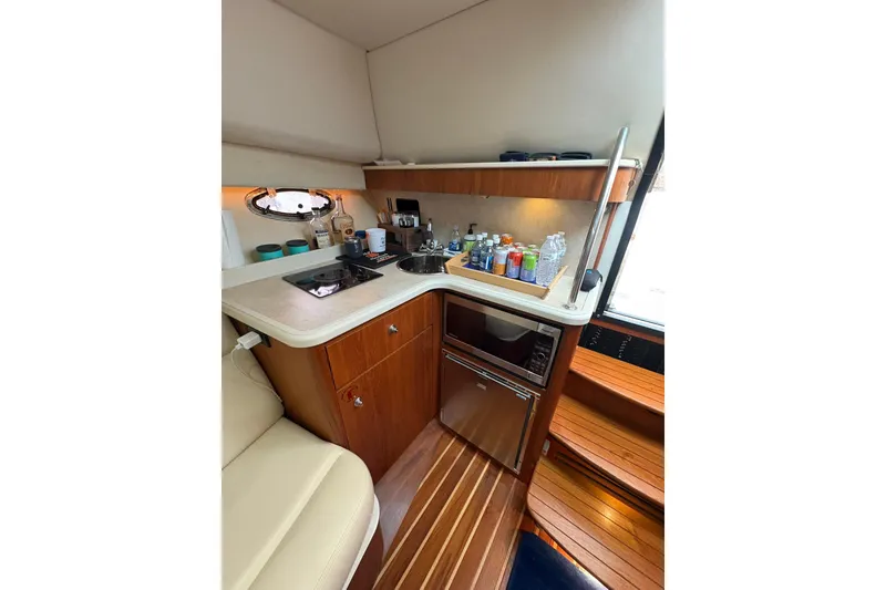 Slide: The Image of Compact galley in 2008 Tiara Yachts 3000 Open, featuring stove, sink, and microwave. - 35