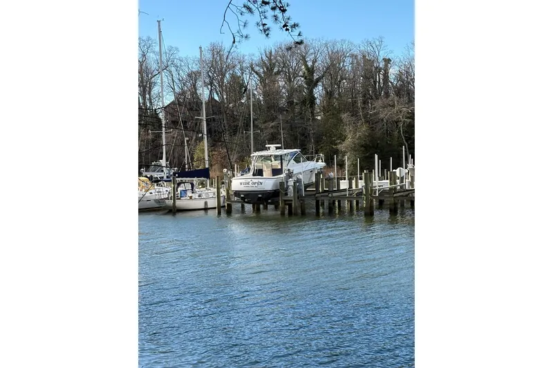 Slide: The Image of 2008 Tiara Yachts 3000 Open docked by a serene waterfront with trees. - 41