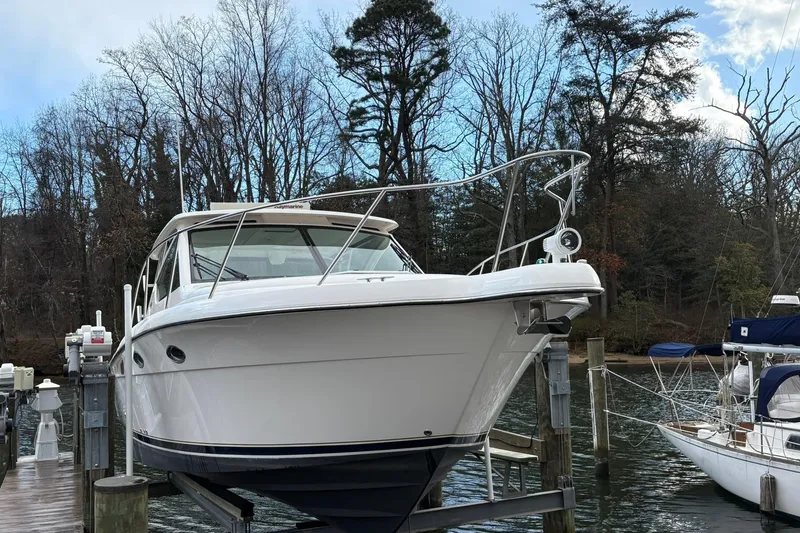 Slide: The Image of 2008 Tiara Yachts 3000 Open docked, surrounded by trees and calm water. - 6