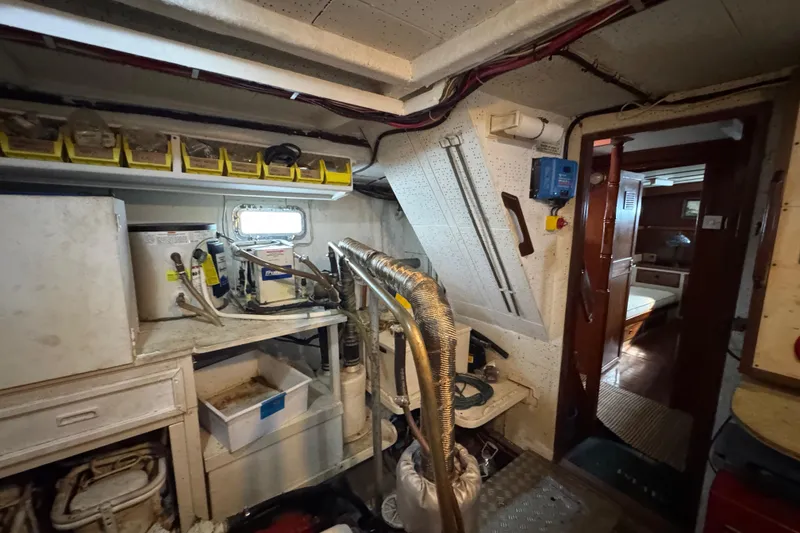 Slide: The Image of Engine room of a 1979 Cheoy Lee 46 LRC yacht, featuring equipment and storage. - 49