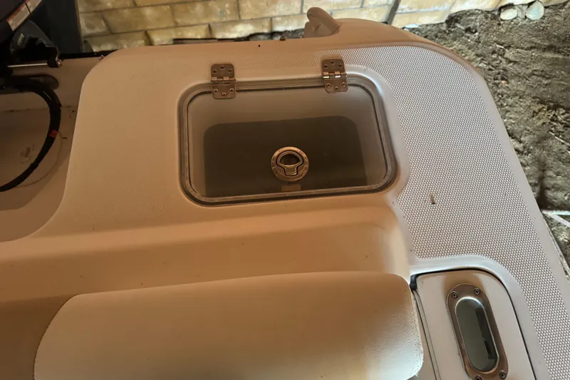 Slide: The Image of 2017 Edgewater 248CX Crossover boat detail showing a storage compartment with a transparent lid. - 10