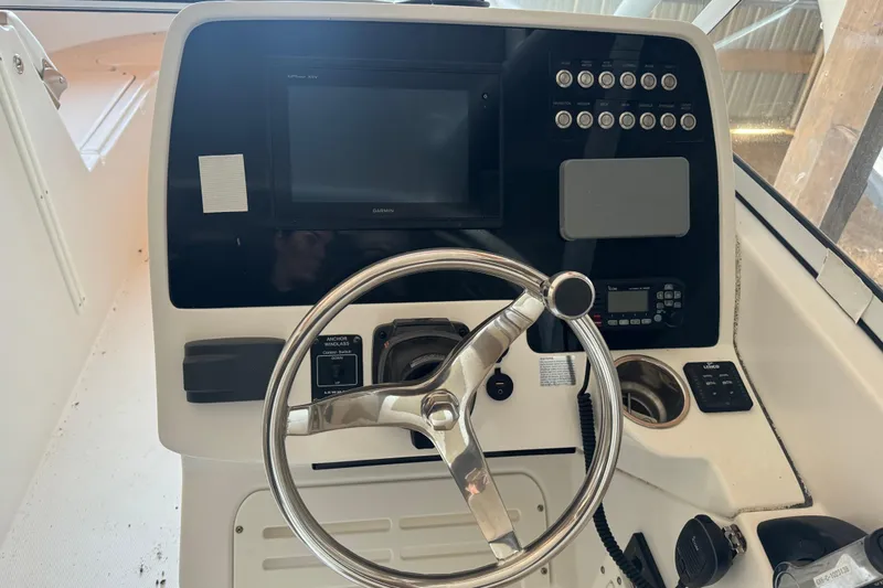 Slide: The Image of 2017 Edgewater 248CX Crossover boat dashboard with steering wheel and control panel. - 12