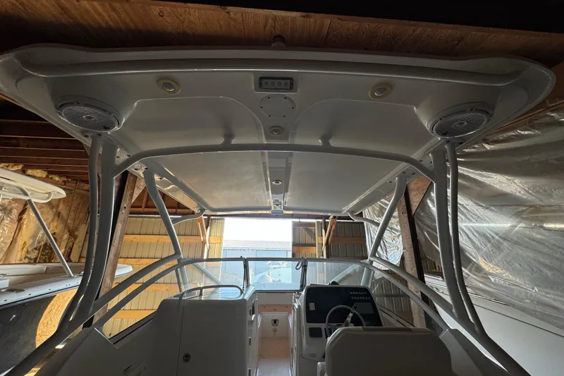 Slide: The Image of 2017 Edgewater 248CX Crossover boat interior with helm and overhead speakers. - 13