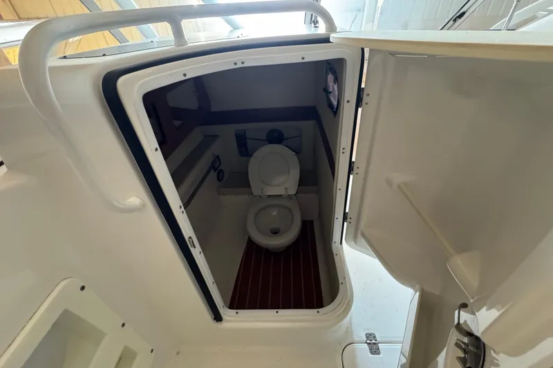 Slide: The Image of 2017 Edgewater 248CX Crossover boat interior with compact marine toilet. - 14