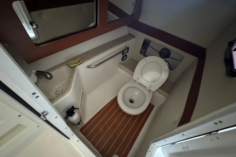 Slide: The Image of 2017 Edgewater 248CX Crossover boat bathroom with toilet, sink, and mirror. - 15