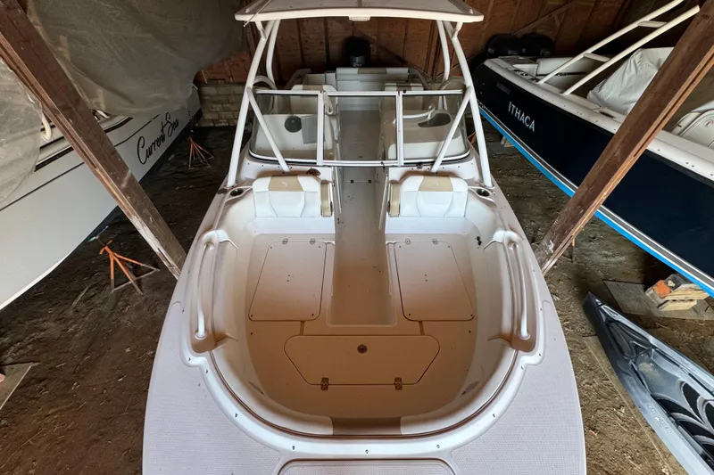 Slide: The Image of 2017 Edgewater 248CX Crossover boat in storage, showcasing spacious deck and seating. - 16