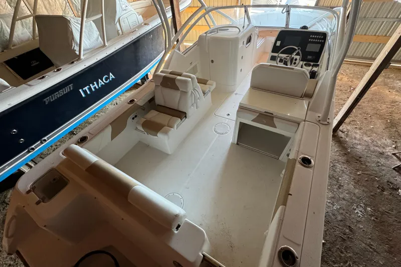 Slide: The Image of 2017 Edgewater 248CX Crossover boat interior with seating and control panel in storage. - 3