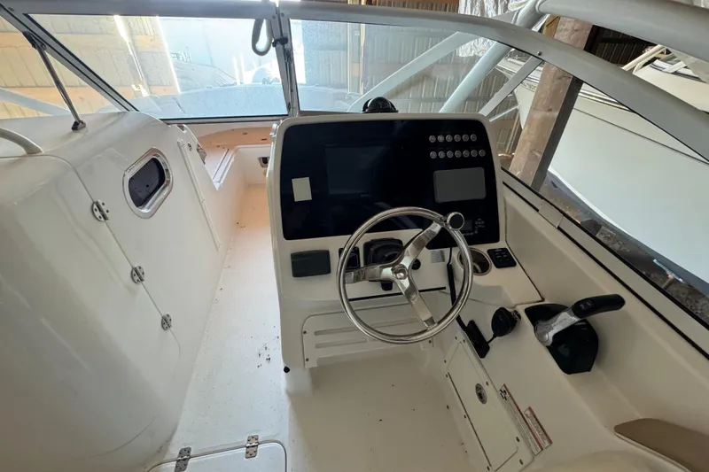 Slide: The Image of 2017 Edgewater 248CX Crossover boat cockpit with steering wheel and control panel. - 4