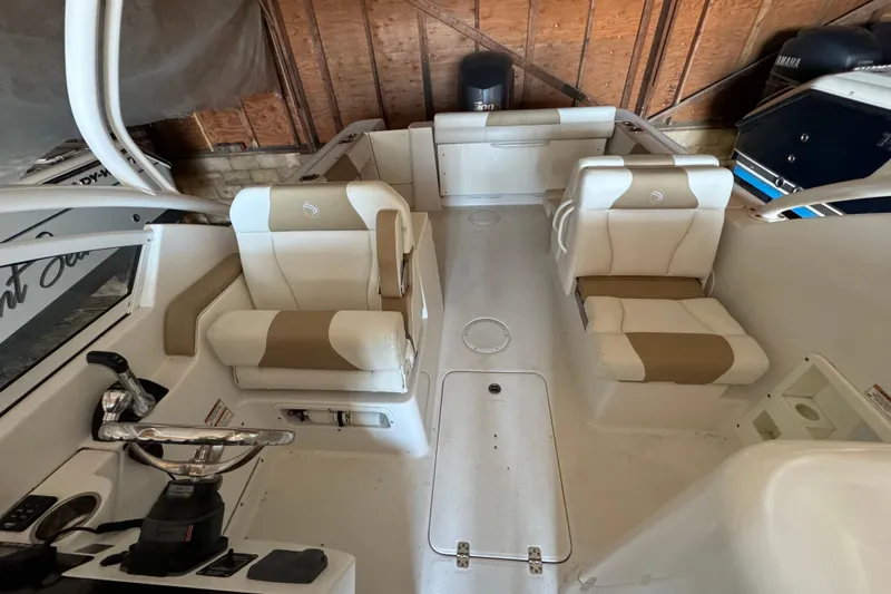 Slide: The Image of 2017 Edgewater 248CX Crossover boat interior with beige and white seating. - 6