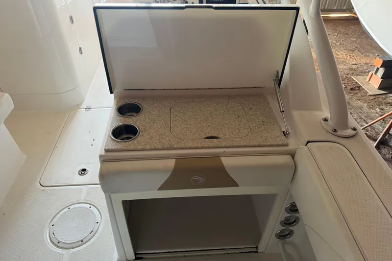 Slide: The Image of 2017 Edgewater 248CX Crossover boat interior with cup holders and storage compartment. - 7