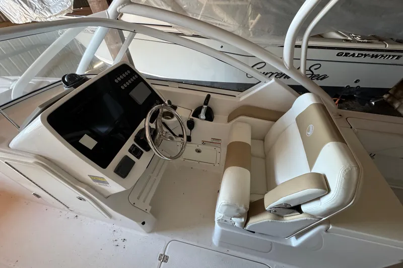 Slide: The Image of 2017 Edgewater 248CX Crossover boat interior with steering wheel and seating. - 9