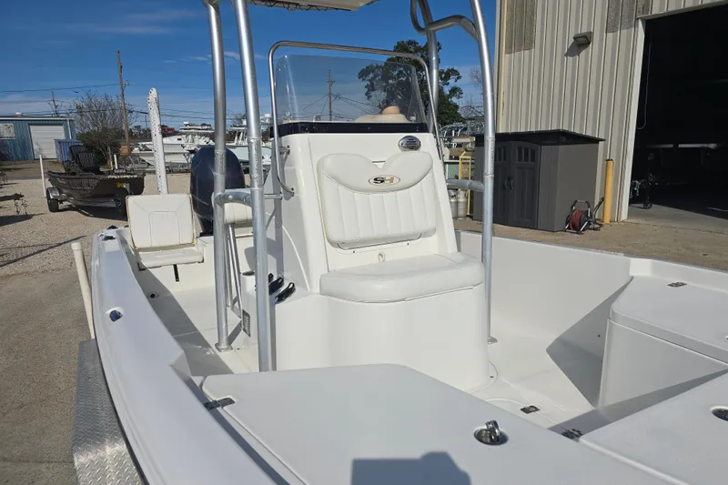 Slide: The Image of 2013 Sea Hunt XP 21 boat with center console and seating, docked outdoors. - 13
