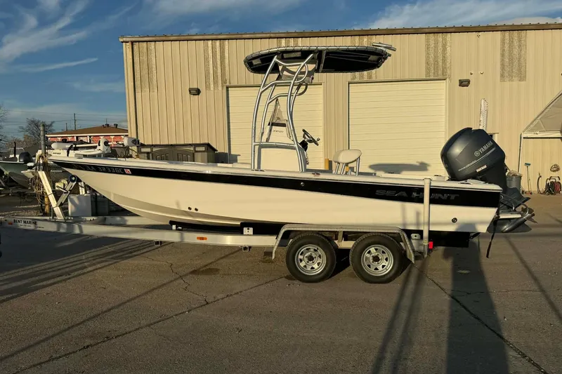 Slide: The Image of 2013 Sea Hunt XP 21 boat on trailer, parked outside a warehouse. - 8