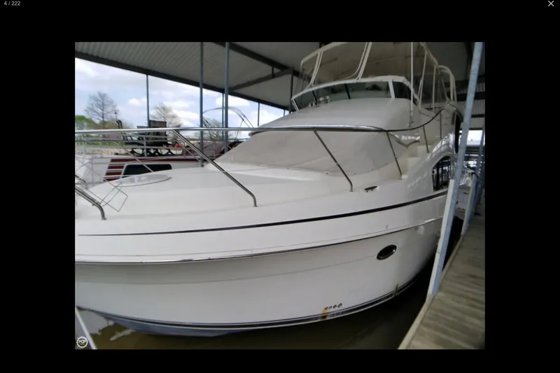Slide: The Image of 2006 Silverton 35 Motor Yacht docked at a marina under a clear blue sky. - 13