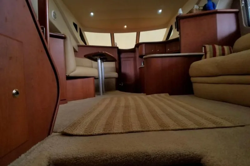 Slide: The Image of Interior of 2006 Silverton 35 Motor Yacht with white seating and carpeted floor. - 23