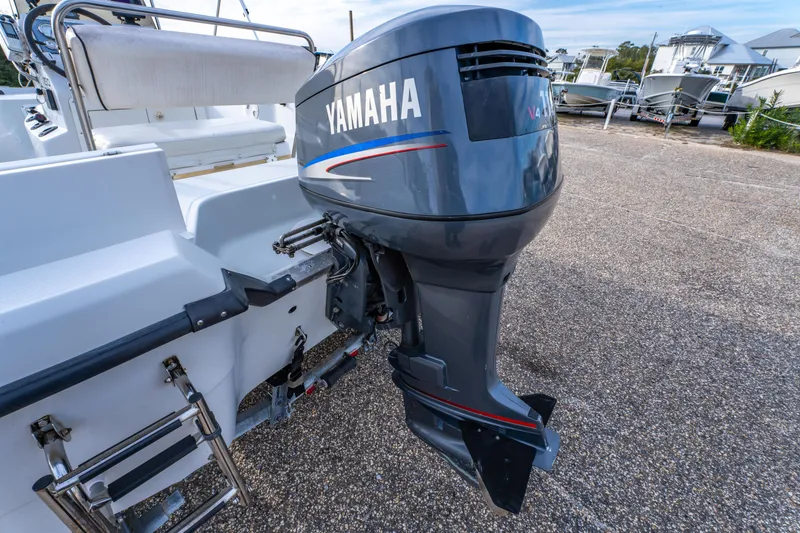 Slide: The Image of 2002 ProMaster 190 BAY boat on trailer, parked outdoors under a clear blue sky. - 11