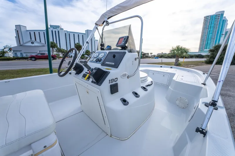 Slide: The Image of 2002 ProMaster 190 BAY boat with steering console, docked near coastal buildings. - 17