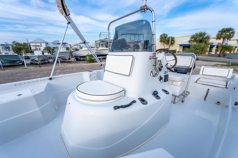 Slide: The Image of 2002 ProMaster 190 BAY boat interior with seating and console, docked near buildings. - 19