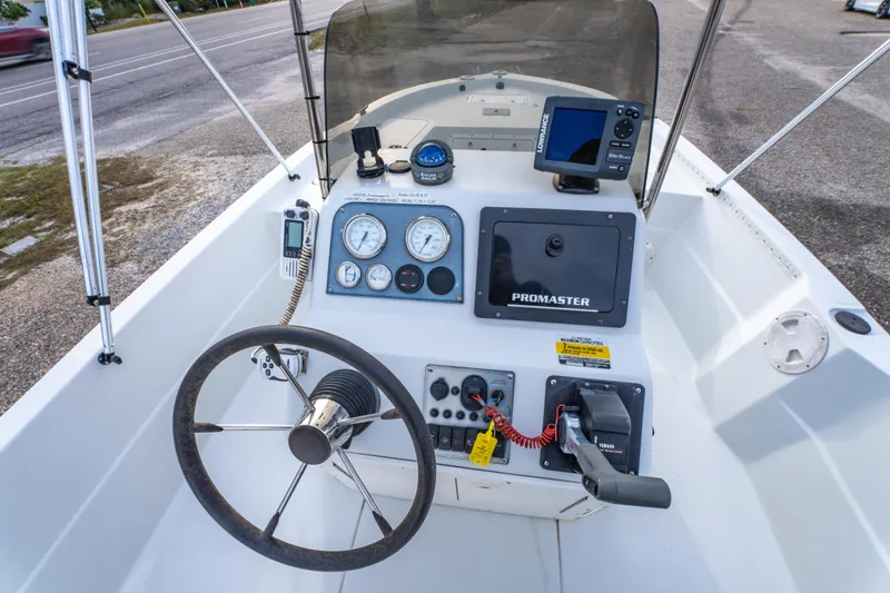Slide: The Image of 2002 ProMaster 190 BAY boat dashboard with steering wheel and navigation instruments. - 21