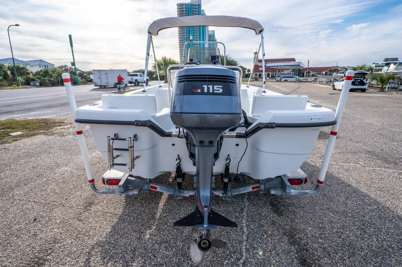 Slide: The Image of 2002 ProMaster 190 BAY boat on trailer with Yamaha outboard motor, parked near a hotel. - 6