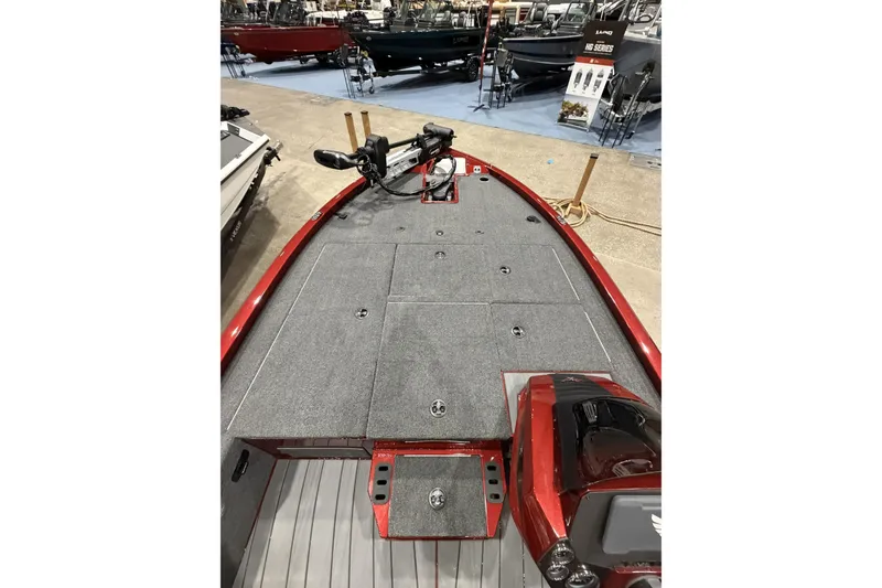 Slide: The Image of 2026 Vexus AVX 1880c boat interior with gray carpet and red accents, displayed at a boat show. - 8
