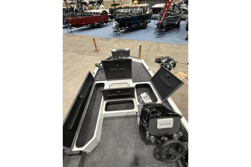Slide: The Image of 2026 Vexus Defender 189 boat interior with open storage compartments and Garmin navigation system. - 11