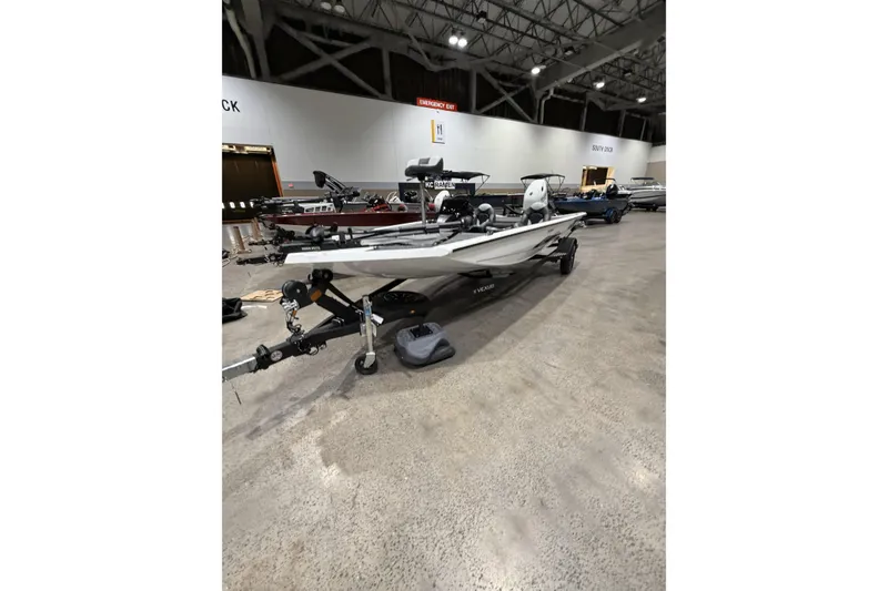 Slide: The Image of 2026 Vexus Defender 189 boat displayed indoors on a trailer. - 2