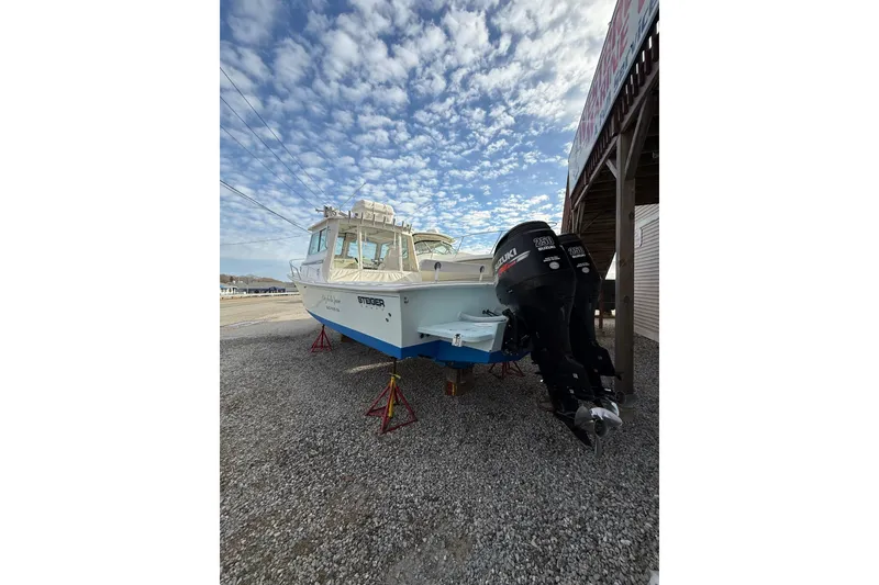 Slide: The Image of 2007 Steiger Craft 26 Miami boat with twin Suzuki engines on gravel lot. - 2