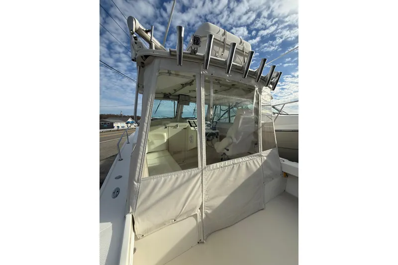 Slide: The Image of 2007 Steiger Craft 26 Miami boat with enclosed cockpit under a partly cloudy sky. - 7